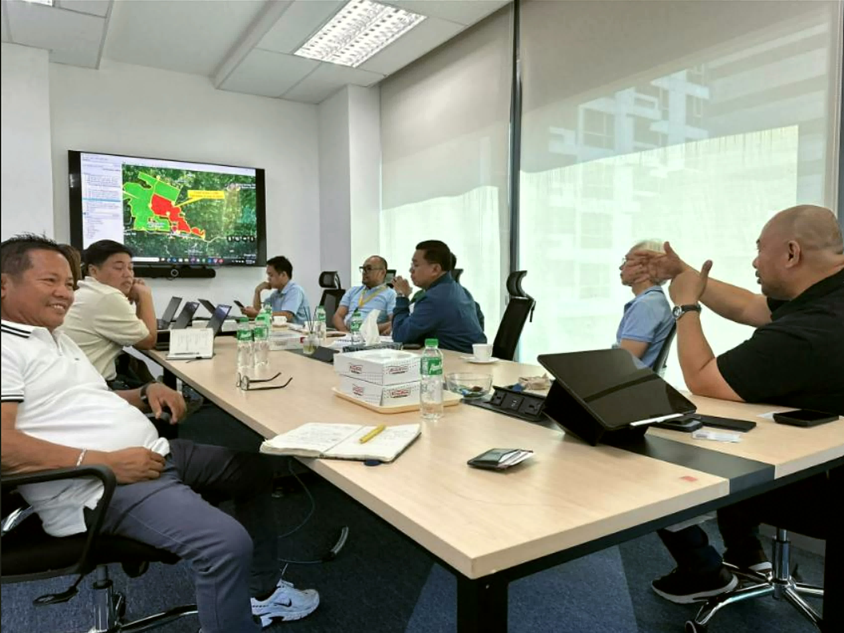 Norodin Yasin and development partners in a boardroom reviewing a land-use map for a real estate development