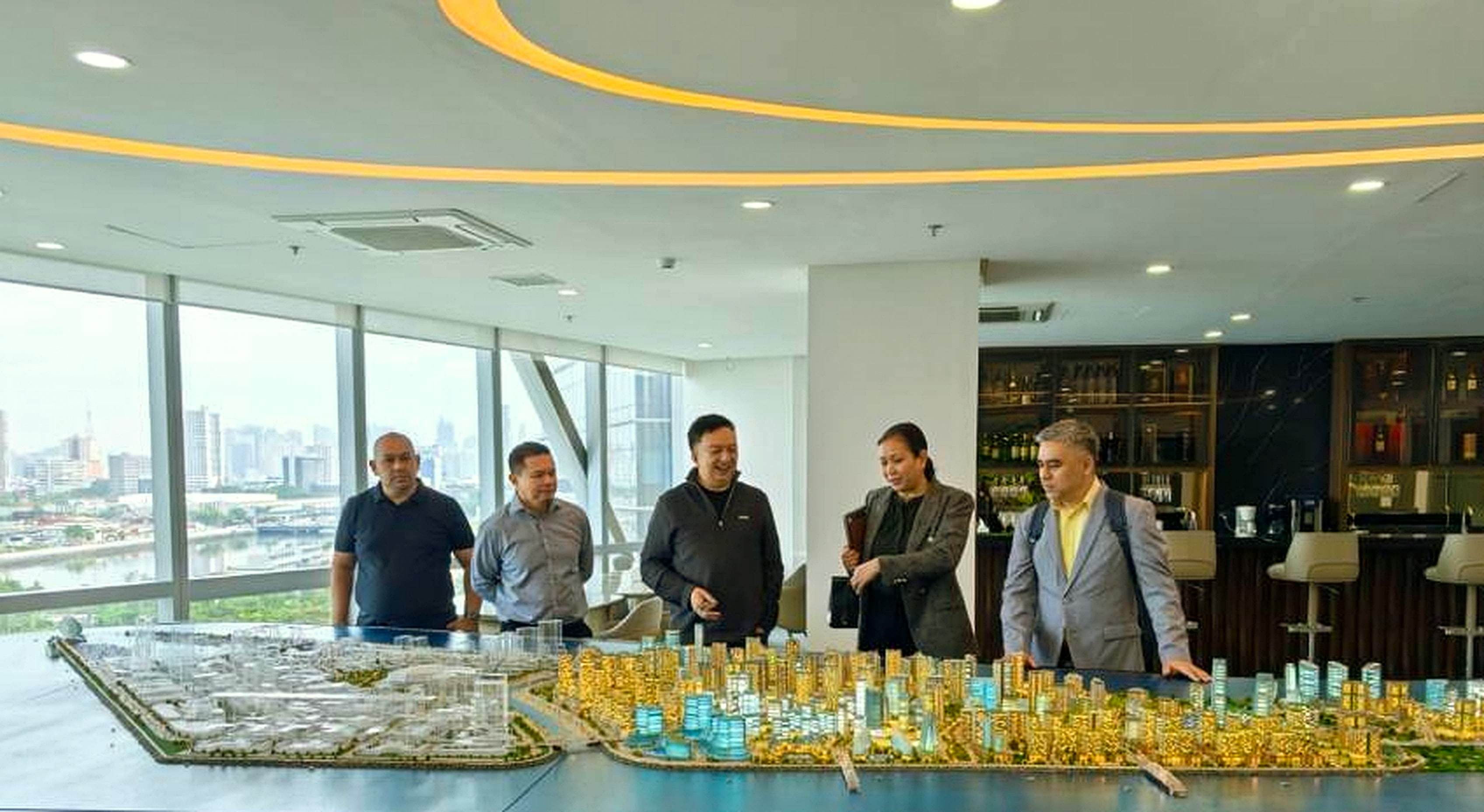 Norodin Yasin and partners reviewing a golden master-plan city model during an investment presentation